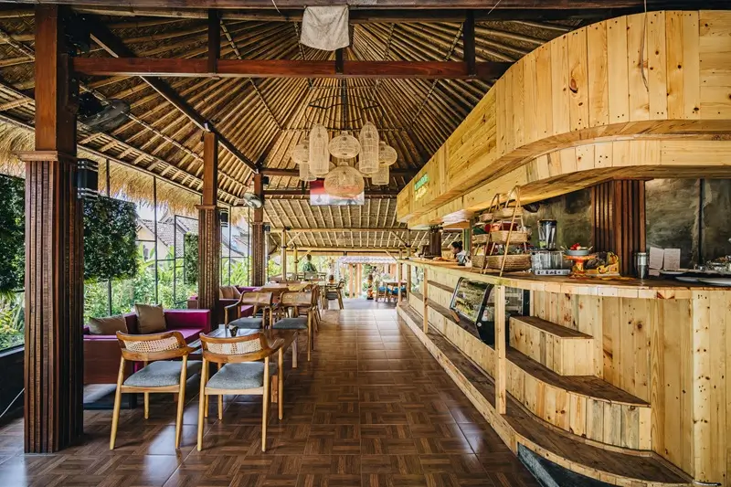 Open-air dining hall and juice bar under a Balinese thatched roof at Bali Yoga Retreats