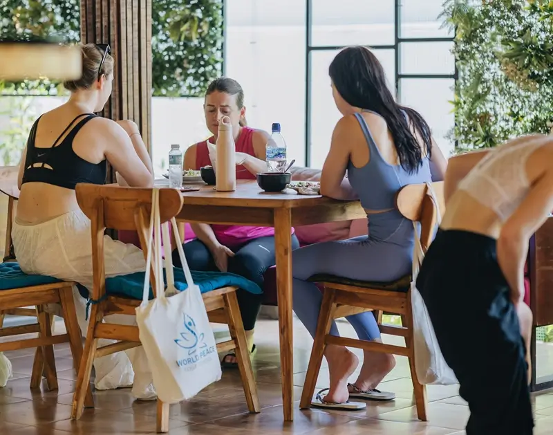 Yoga retreat guests sharing a meal together in the dining hall in Ubud