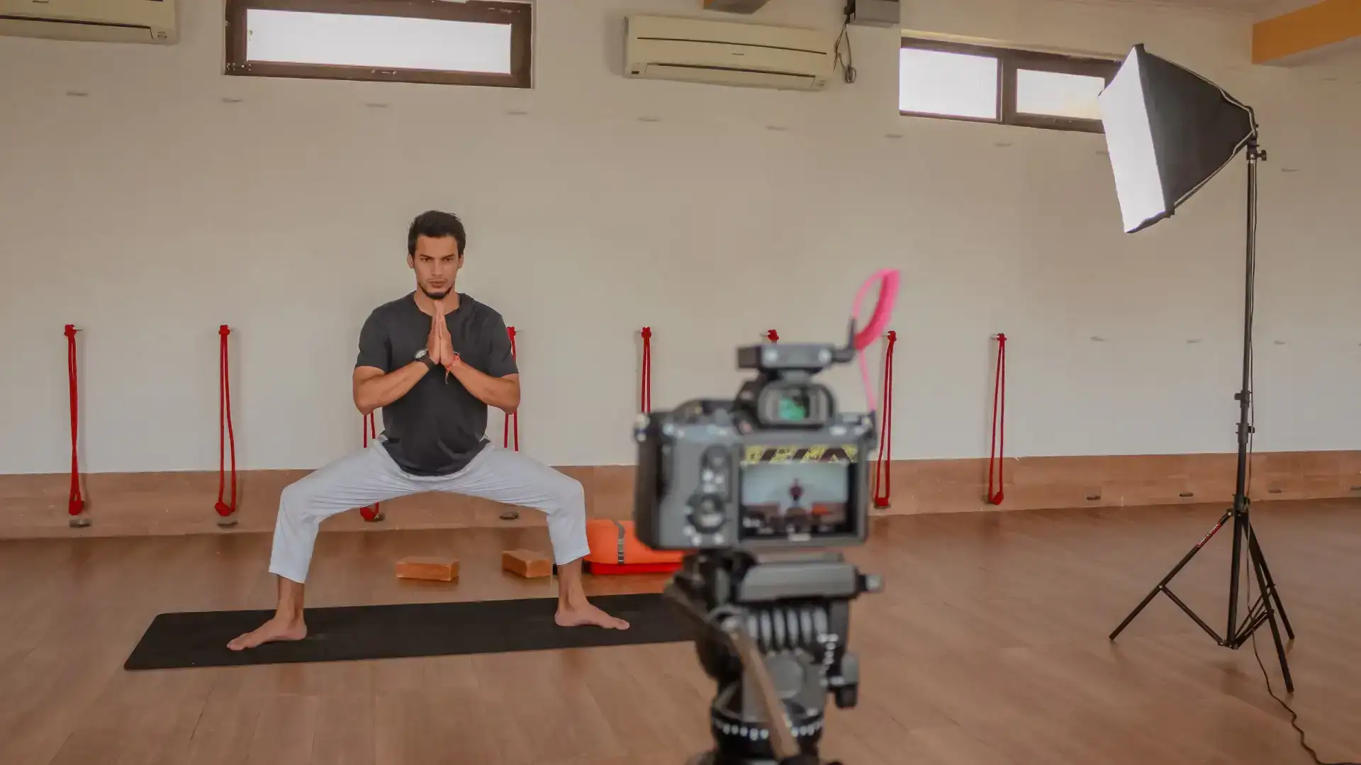 Yoga instructor recording a video while practicing a pose