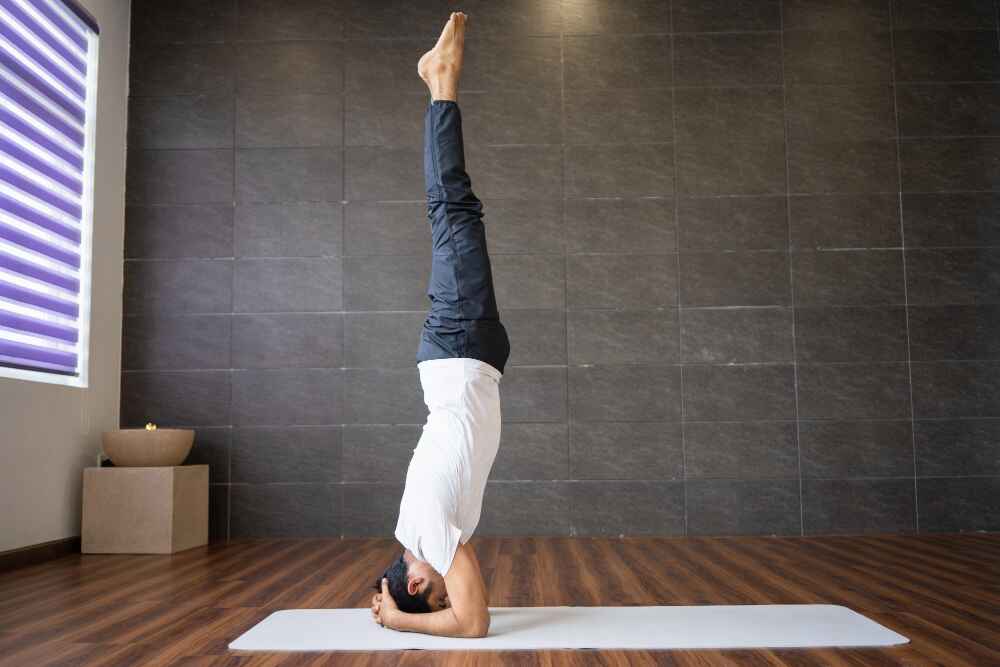 Men Doing Sirsasana (Headstand) on yoga mat