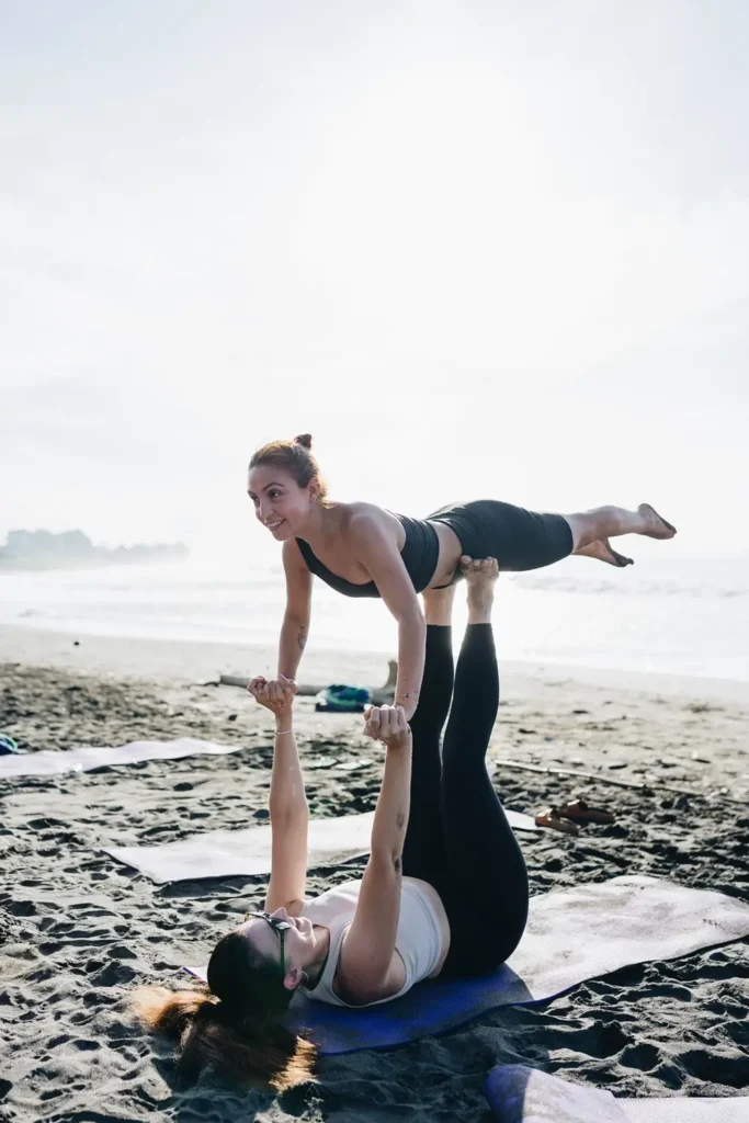 Students practicing yoga on beach