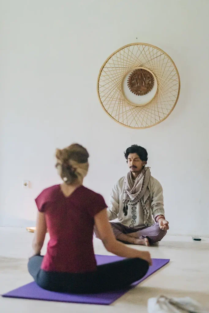 Yoga meditation class with instructor and student practicing mindfulness